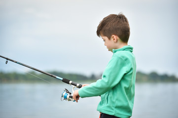 child boy holds fishing rod