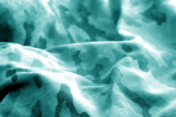 Old camouflage cloth with blur effect in cyan tone.