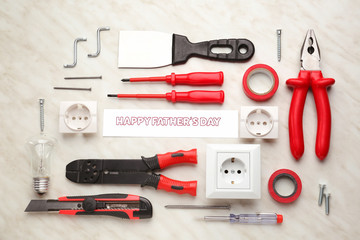 Different tools and card with text "Happy Father's Day" on light background