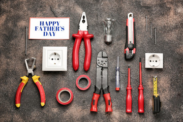 Different tools and card with text "Happy Father's Day" on grunge background