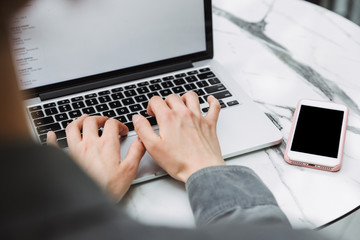 Close up of a woman working on a blank screen laptop