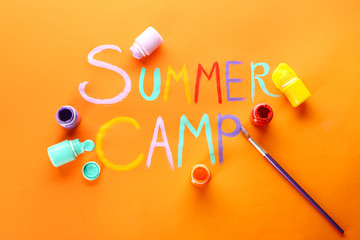 Words SUMMER CAMP, paints and brush on color background