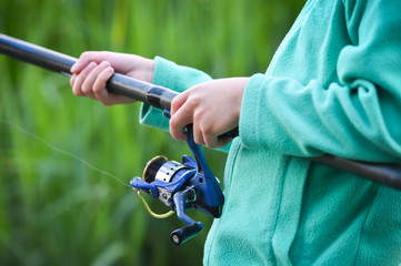 child boy holds fishing rod