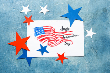 Paper sheet with drawing of USA flag and text HAPPY INDEPENDENCE DAY on color background