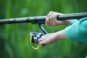 child boy holds fishing rod
