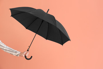 Female hand with stylish umbrella on color background © Pixel-Shot