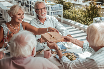 Charming mature woman giving present to her mom