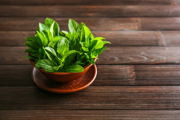 Bowl of fresh mint on wooden background