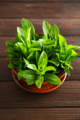 Bowl of fresh mint on wooden background