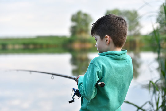 Child Boy Holds Fishing Rod