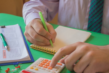 Businessman working on office desk with Calculator,  a pen and document