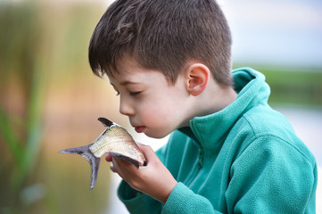 little boy kissing a fish