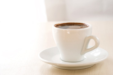 A cup of coffee on a light beige background. Template for design, menu.