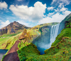 Colorful summer scene with pure water of Skogafoss Waterfall. Sunny morning on the Skoga river,...