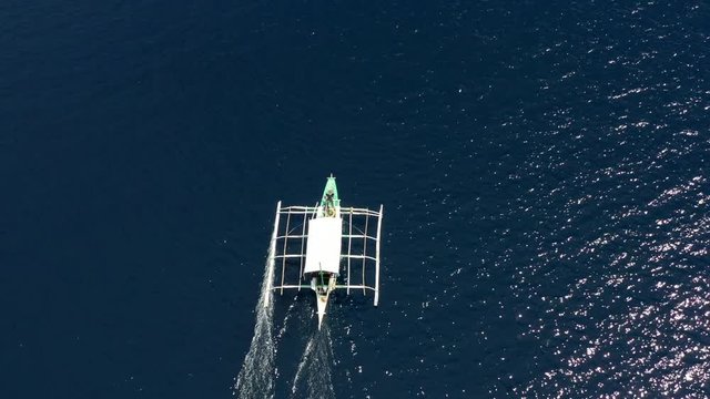 Aerial view of Filipino boats floating on top of clear blue waters, Moalboal is a deep clean blue ocean and has many local Filipino boats in the sea. Moalboal, Cebu, Philippines.