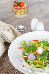 Fresh spring edible flowers salad and chia seed pudding served on the table, light healthy summer