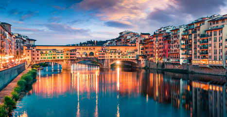 Fototapeta na wymiar Splendid medieval arched river bridge with Roman origins - Ponte Vecchio over Arno river. Colorful spring sunset view of Florence, Italy, Europe. Traveling concept background.