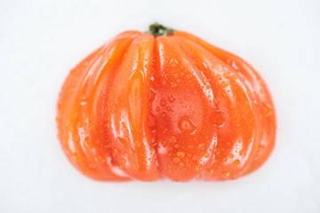 top view of wet red ripe tomato with drops isolated on white