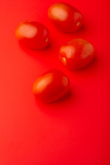 red tomatoes on a red background, creative concept, with space