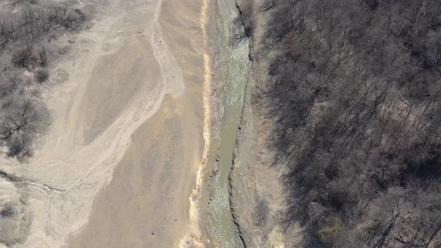 River stream with mining drainage pyrite on coast 4K drone footage