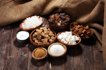 Various types of sugar, brown sugar and white on rustic wooden table