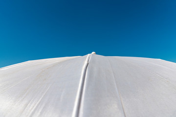 White parasol on  a blue sky background