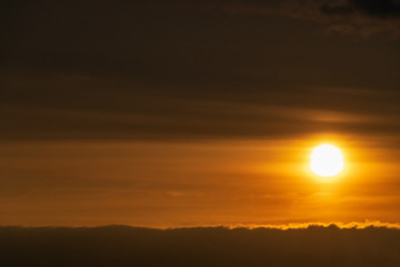 Natural beautiful orange sunset. Bright sky and big sun close up. The sun above the horizon, the horizon. Warm colors.