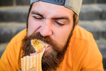 Unleashed appetite. Street food concept. Man bearded eat tasty sausage. Urban lifestyle nutrition....