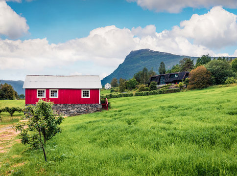 Typical countryside Norwegian landscape with red painted wall house. Picturesque summer morning in Norway, Europe. Beauty of nature concept background. Artistic style post processed photo.