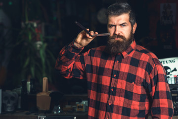Close up cropped photo of a styling of a red beard. Bearded man, bearded male. Straight razors,...