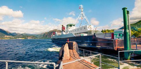 Picturesque summer view of the Norwegian farry crossing through the fjord. Sunny morning seascape of North sea, Norway, Europe. Traveling concept background.