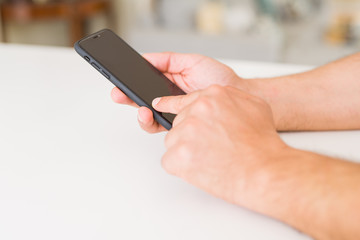 Close up of middle age man hands using smartphone at home