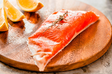 Raw salmon fish filet with lemon and spices. On a wooden background.Healthy food, diet or cooking concept.
