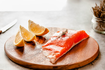 Raw salmon fish filet with lemon and spices. On a wooden background.
