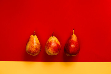 Yellow-red pears on a colored background. Vitamins, organic products, autumn harvest, vegetarianism, energy and juicy. Postcard for decor, flat lay, copy space, vibrance fine art.