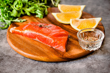 Delicious portion of fresh salmon fillet with aromatic herbs, spices and vegetables - healthy food, diet or cooking concept