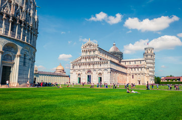 Obraz premium Splendid spring view of famous Leaning Tower in Pisa. Sunny morning scene with hundreds of tourists in Piazza dei Miracoli (Square of Miracles), Italy, Europe. Traveling concept background.