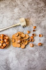 Hazelnuts in the shell in a small bowl and nutcracker. On a gray background. Top view. Copy space for text.