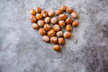 Obraz premium Heart of hazelnut in the shell. On a light gray background. Love healthy natural food concept