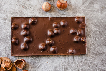 Homemade hazelnut chocolate bar. Nuts and chocolate background. Ingredients for cooking homemade chocolate sweets. Confectionery and sweets concept