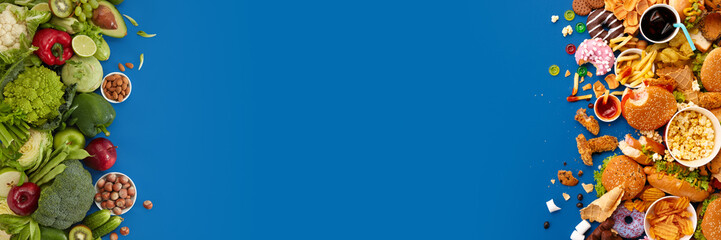 Fast food dish and health food on blue background. Take away unhealthy set including burgers, sauces, french fries. Comparison with healthy nutrition, vegetables and fruits. Flyer for your ad.