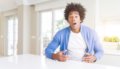 African American man at home afraid and shocked with surprise expression, fear and excited face.