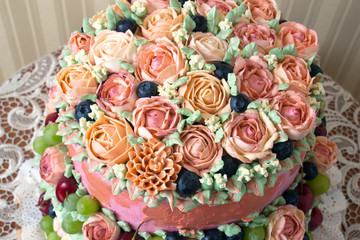 Obraz na płótnie Canvas Vintage cake with cream rose flowers and fruits on a table