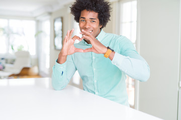 Fototapeta na wymiar African American business man wearing elegant shirt smiling in love showing heart symbol and shape with hands. Romantic concept.