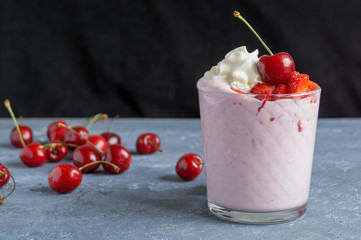 Milkshake with cherries. on a gray background.