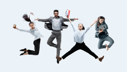 Fototapeta na wymiar Let's start with aroma coffee. Happy office workers jumping and dancing in casual clothes or suit with drinks and folders isolated on studio background. Business, start-up, working open-space concept.
