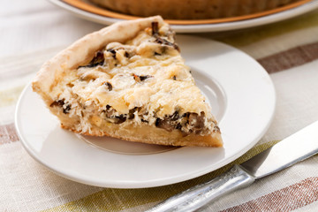 Slice of chicken tart with mushrooms and cheese on a plate