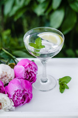 Mojito and summer  flowers. Beautiful flat lay with water with mint and lemon and peonies. Close up