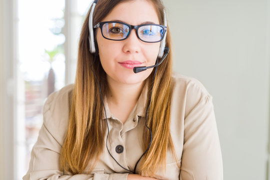 Beautiful young operator woman wearing headset at the office Relaxed with serious expression on face. Simple and natural with crossed arms