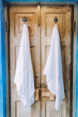 Two white towels hanging on rustic hangers in the bathroom